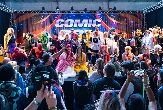 Cosplayers en publiek rond een live podium
